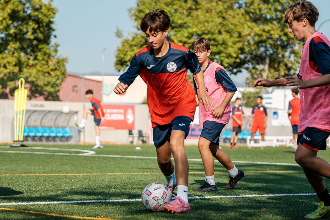 Jugador de Fútbol 11 conduce el balón ante sus compañeros